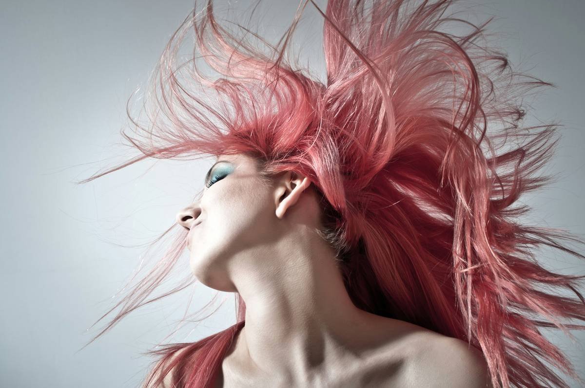 woman styling hair with silk hair scarves for low-friction hold